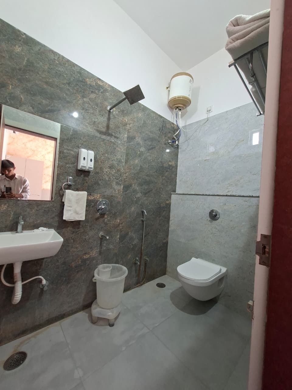 Bathroom with wash basin, mirror and shower at The Ambay Villa Udaipur