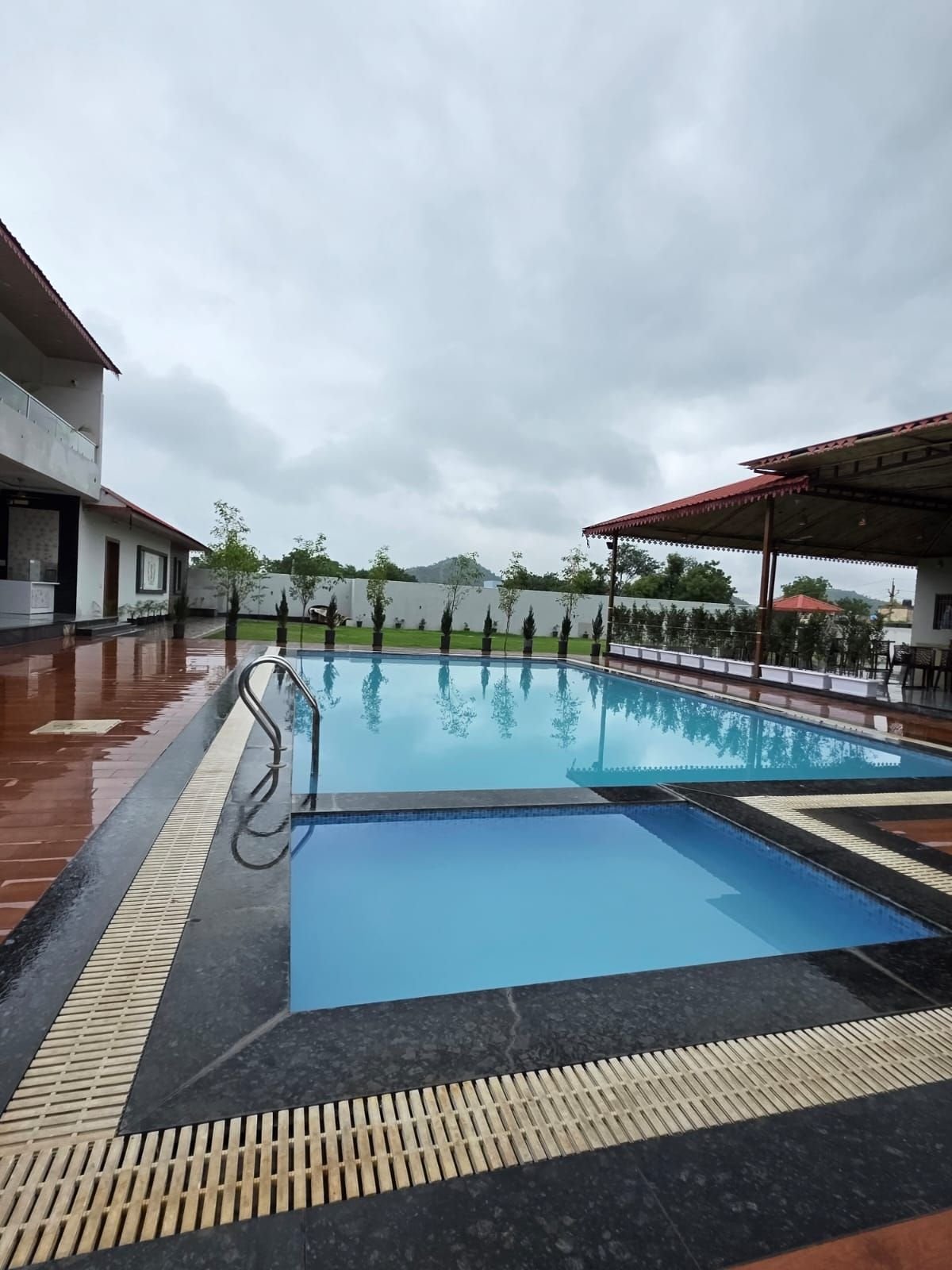Kids' pool and deck at The Ambay Villa Udaipur after the rain